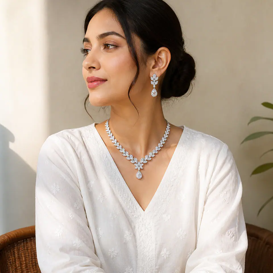 Woman in white kurta wearing Zoya AD drop earrings and Sitara AD pendant set in soft daylight