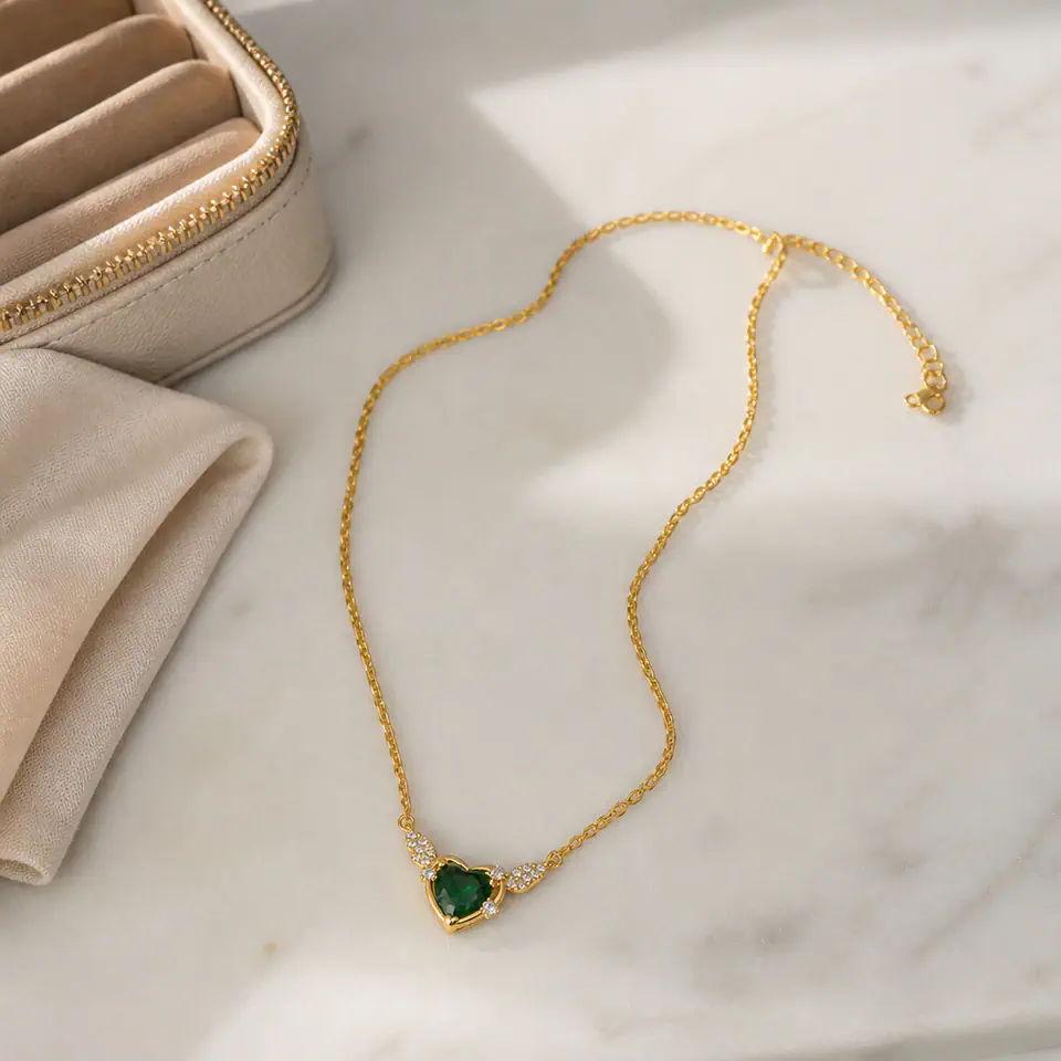 Oxidised necklace laid flat beside a zip pouch and a soft cloth on a marble shelf